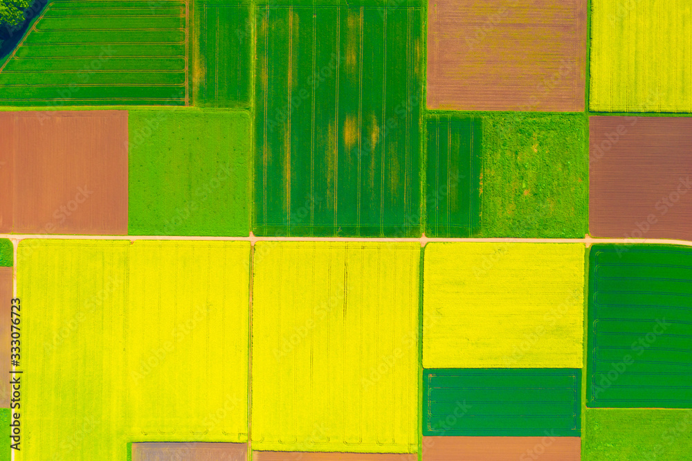 Aerial view of farmlands in spring: Green, red and yellow fields 