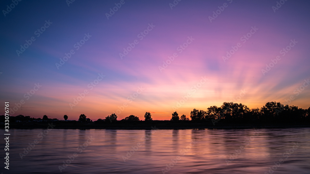 Beautiful lakescape at sunset; colorful sunset in the sky