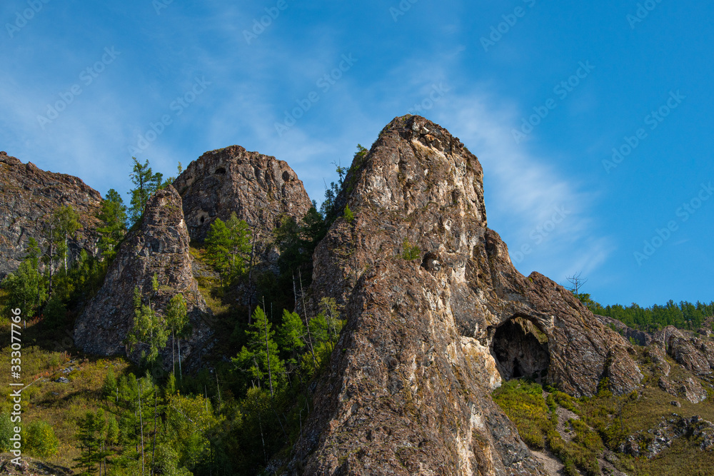 small cave or grotto in mountain cliff, mountaineering and caving in rocks small cave or grotto in mountain cliff, mountaineering and caving in rocks