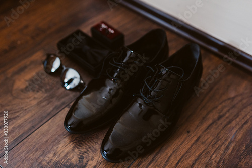  Black shoes, glasses, bows and cuffs on the floor of the room