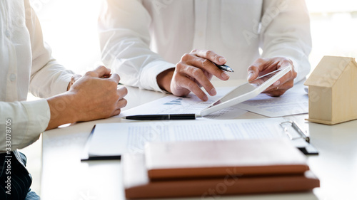 Real Estate Agent broker or House developer showing contract for buying house agreement to consultant employee. photo