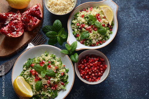 Healthy salad with couscous, fresh mint, cucumber, pomegranate, lemon and olive oil. Eastern cuisine. Vegan food concept. Traditional Israeli food