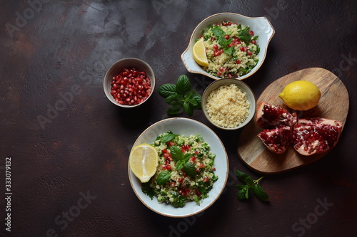 Healthy salad with couscous, fresh mint, cucumber, pomegranate, lemon and olive oil. Eastern cuisine. Vegan food concept. Traditional Israeli food