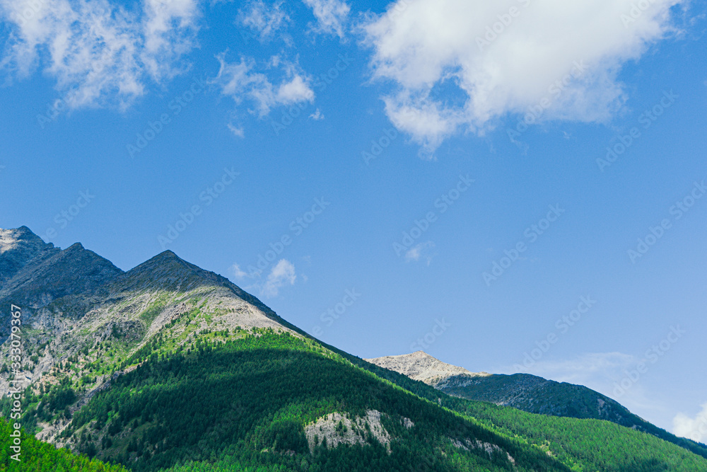 mountain valley under blue sky for trekking and adventure, rock ridge on horizon
