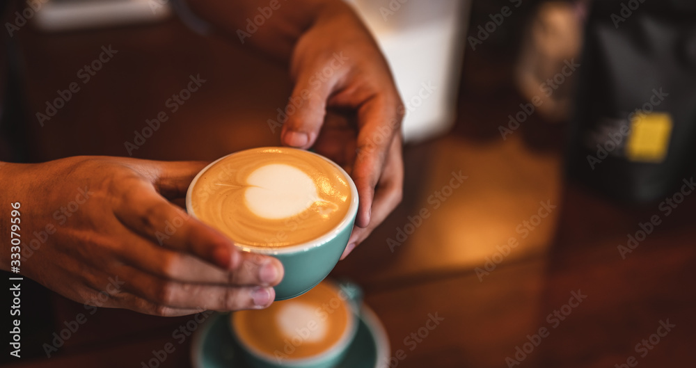Close up of hands barista man serving coffee in coffee shop. male hands placing a cup of coffee on table. Coffee, Barista, extraction, serve, cafe, lifestyle concept. Close up of hands barista man serving coffee in coffee shop. male hands placing a cup of coffee on table. Coffee, Barista, extraction, serve, cafe, lifestyle concept.