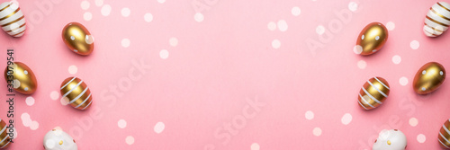 Easter egg background with golden shine decorated eggs in basket isolated on pink. Happy Easter © Maksym