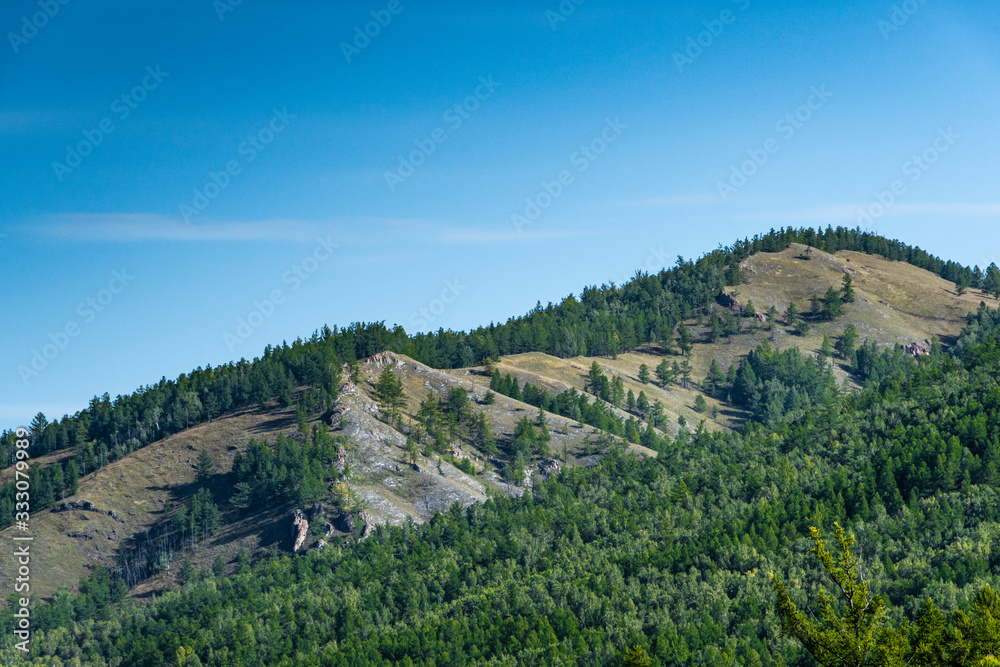 gentle green hills under blue cloudy sky, panorama of mountain landscape, valley for summer hiking