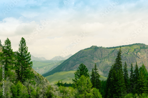 mountain valley with trees and hills under cloudy sky, place for meditation and hiking