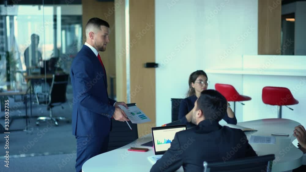 Corporate business people in formal clothing discussing contract negotiations during briefing process at table desktop in conference room, male and female collaborating during team building Corporate business people in formal clothing discussing contract negotiations during briefing process at table desktop in conference room, male and female collaborating during team building