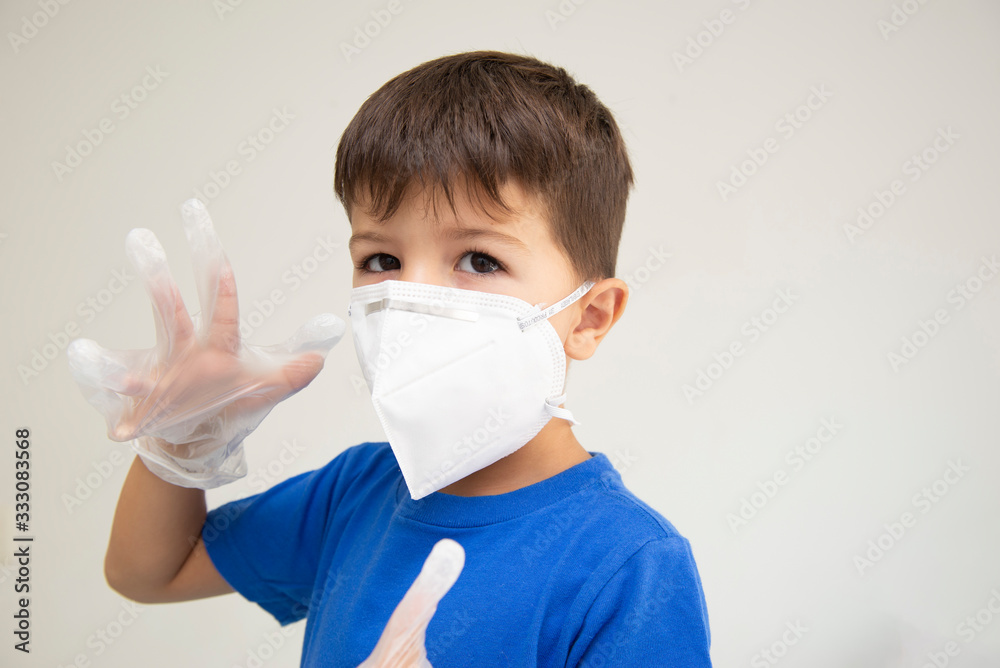 Boy wearing mask and surgical gloves gesturing with his hands Boy wearing mask and surgical gloves gesturing with his hands