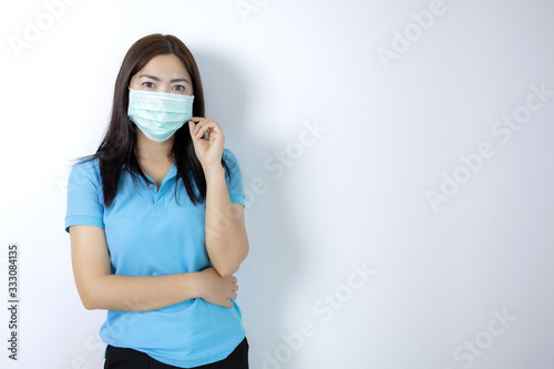 Asian women wear masks to prevent disease covid 19, long haired-black women. Wearing a blue collar shirt. Woman holding hands with a mask on white background.
