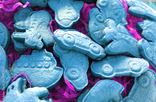 Christmas holiday sugar shortbread cookies. Bright colored figures of cakes made of space sand, dough, plasticine in the form of a car, plane, train close-up. Food as background and texture
