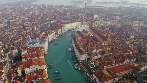 Aerial, tilt up, drone shot over the canal Grande, misty sunset, in Venice city, Italy photo