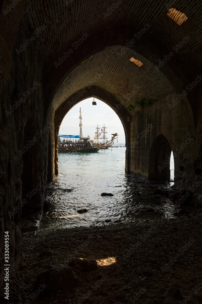 Alanya. Turkey. Traditional entertainment resort of Alanya. Sailing aka pirate ships around the fortress of Alanya. View from the medieval shipyard (Tersane) of the Alanya Castle.
