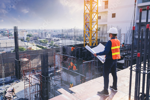 Αφίσα Smart civil architect engineer inspecting and working outdoors building side with blueprints