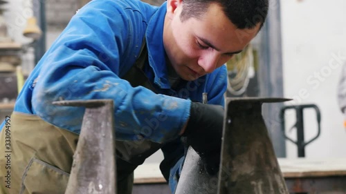 Concrete workshop - the master untwisting a concrete form with a screw photo