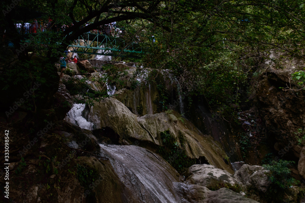 Group of people enjoying under the famous neer garh Waterfall, Rishikesh, Uttarakhand India. Group of people enjoying under the famous neer garh Waterfall, Rishikesh, Uttarakhand India.