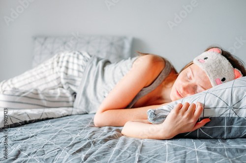 Woman with long hair in her bedroom sleeping