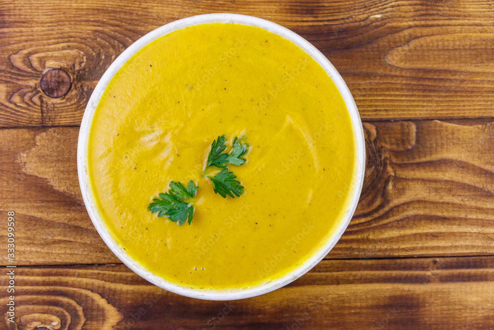 Pumpkin soup on a wooden table. Top view Pumpkin soup on a wooden table. Top view