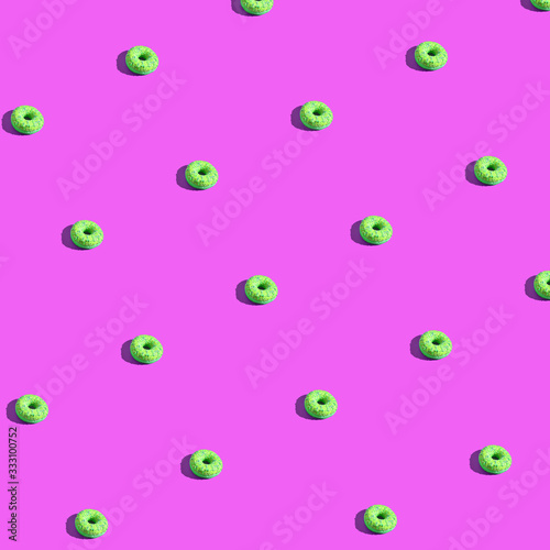 Many donuts square pattern. Set same cakes concept. Hard shadow. Top view colorful background. Pink, light green colors. Unhealthy food art. Circle bright dessert