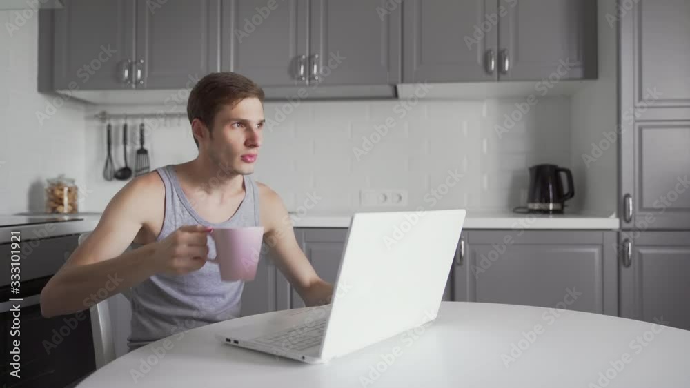 Exhausted man drinking tea and working on laptop computer at home. Tired business man Exhausted man drinking tea and working on laptop computer at home. Tired business man