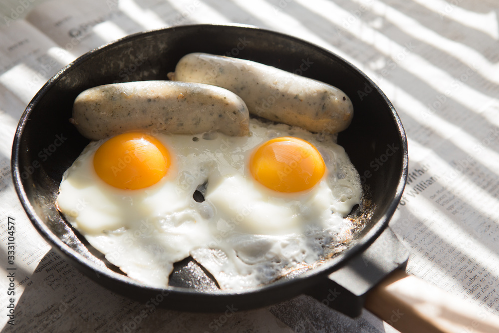 Fried eggs, sausage in iron pan - Healthy food english breakfast Fried eggs, sausage in iron pan - Healthy food english breakfast