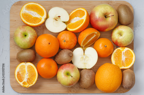 fruit diversity on wooden kitchen Board on grey background of sliced and whole fruits