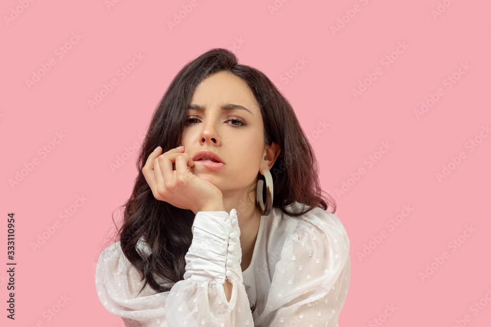 Young pretty brunette woman in a white blouse looking depressed Young pretty brunette woman in a white blouse looking depressed
