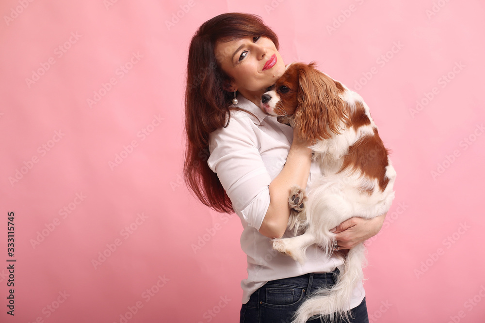 Beautiful girl in a studio. Stylish woman on a pink background. Lady with a dog Beautiful girl in a studio. Stylish woman on a pink background. Lady with a dog