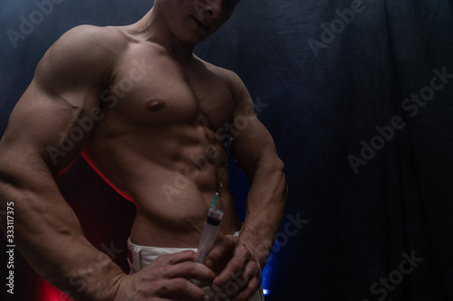 Bodybuilder holding big syringe with injection. concept of steroid in the sport and addiction  photo