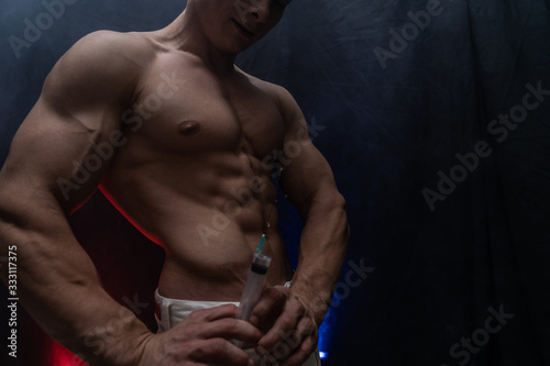 Foto Bodybuilder holding big syringe with injection