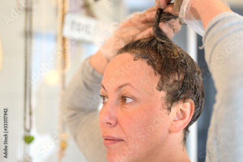 Woman working hair dye through her locks