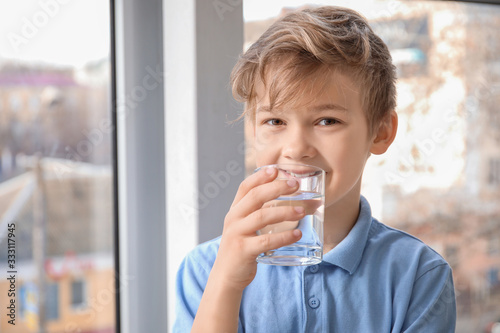 Cute little boy drinking wa...