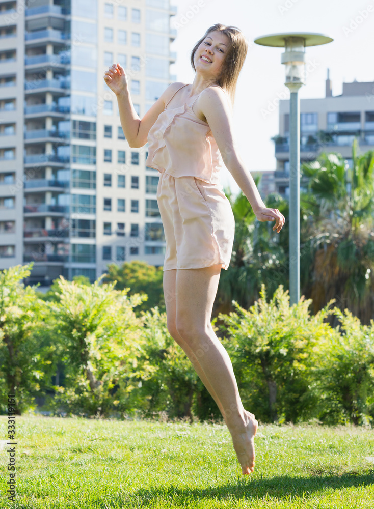 Woman is playfully jumping in the park