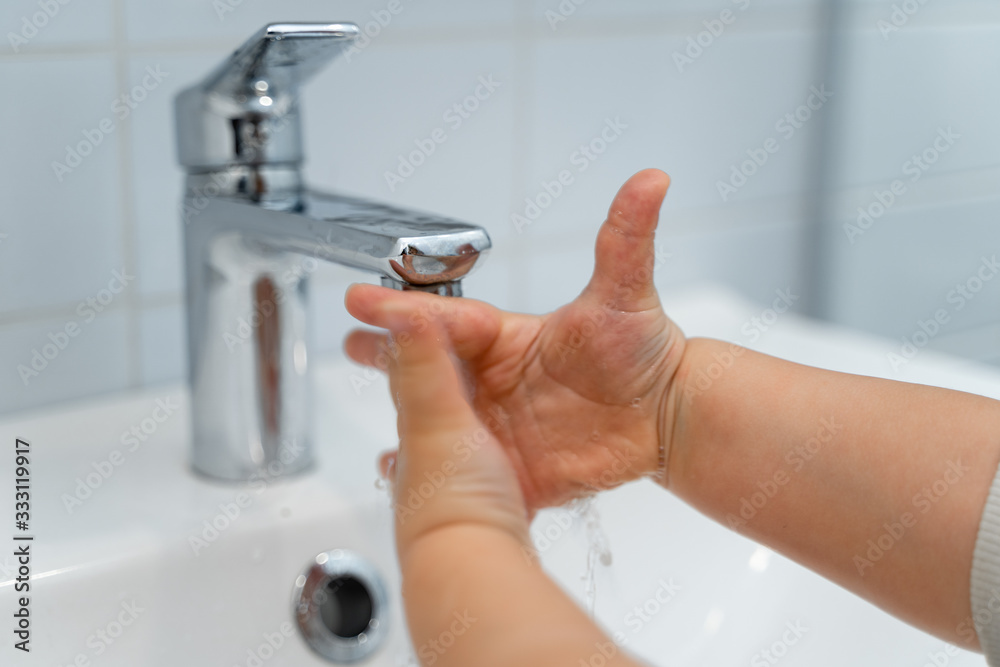 Close up of baby washing hands with liquid soap in the bathroom. Personal hygiene. Covid-19 prevention Close up of baby washing hands with liquid soap in the bathroom. Personal hygiene. Covid-19 prevention