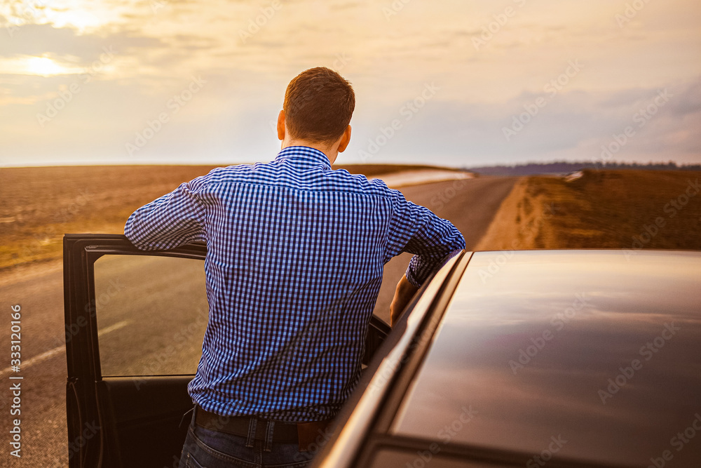 Fototapeta premium Men near the car at sunset