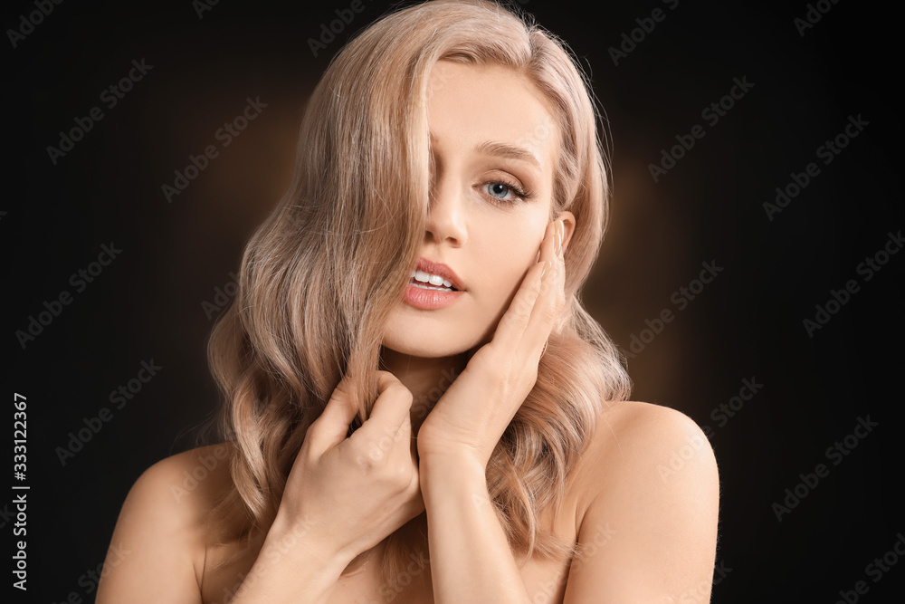 Young blonde with beautiful hair on dark background Young blonde with beautiful hair on dark background