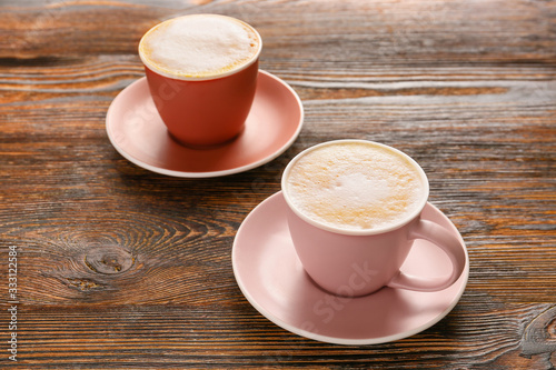 Two frothy cappuccino cups ...