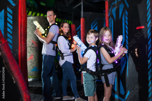 Kids standing back to back with laser pistols