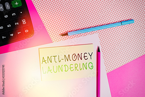 Writing note showing Anti Money Laundering. Business concept for regulations stop generating income through illegal actions writing equipments and plain note paper placed on the table photo