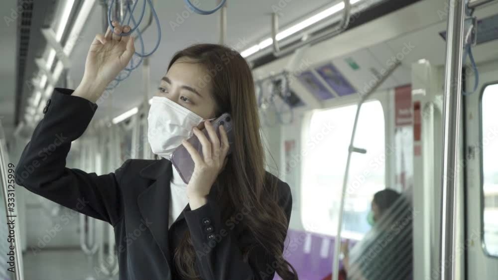 Businessmen are using their smartphones while traveling on the train to work while the coronavirus is spreading. Businessmen are using their smartphones while traveling on the train to work while the coronavirus is spreading.