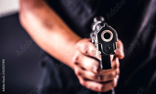 Fotografie, Obraz Killer with gun close-up pointing a gun at the target