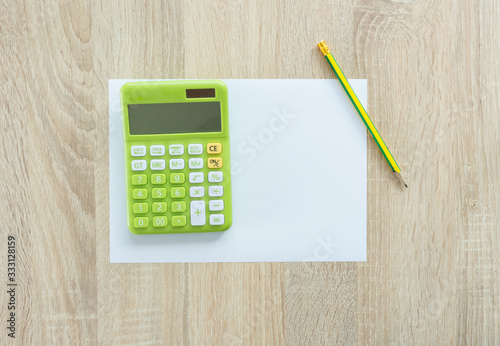 Flat lay of green calculator with other on work desk.
