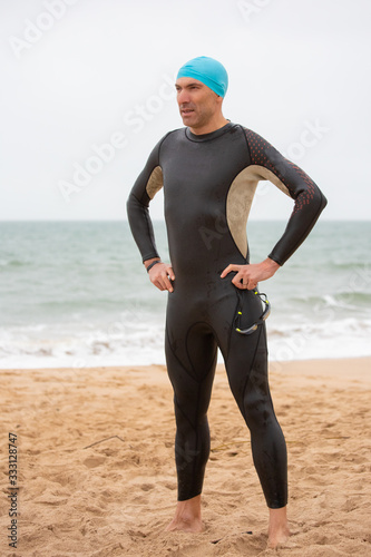 Slika na platnu Serious male swimmer standing on beach