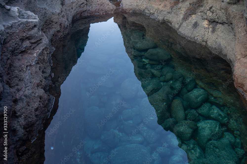 Puddle with crystal clear water.  This photo was taken in Charco Manso.  This puddle is located on the Island of El Hierro, Canary Islands