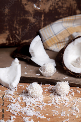 Close up of white candies and coconut with white pulp, coconut chip on wooden background..