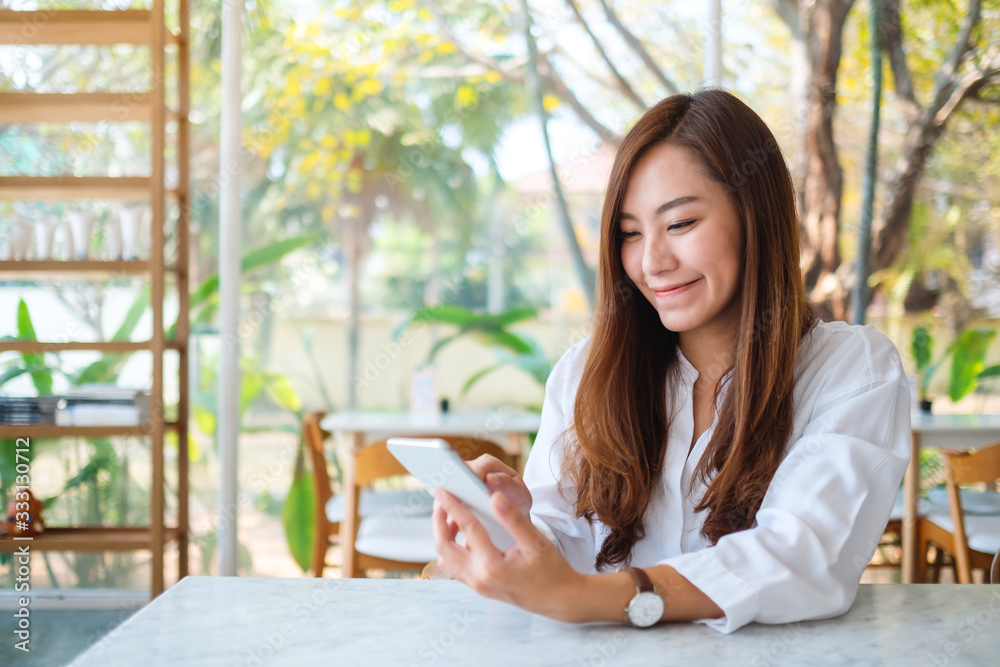 Closeup image of a beautiful asian woman holding and using mobile phone Closeup image of a beautiful asian woman holding and using mobile phone