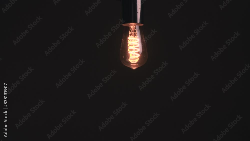 Dark grey gradient background, vintage LED light bulb turns on, off