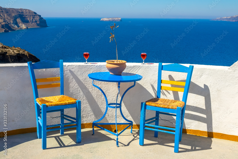 Two Chairs and Two Glasses on a Sunny Rocky Shore