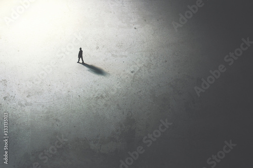 man walking in the night toward the light photo